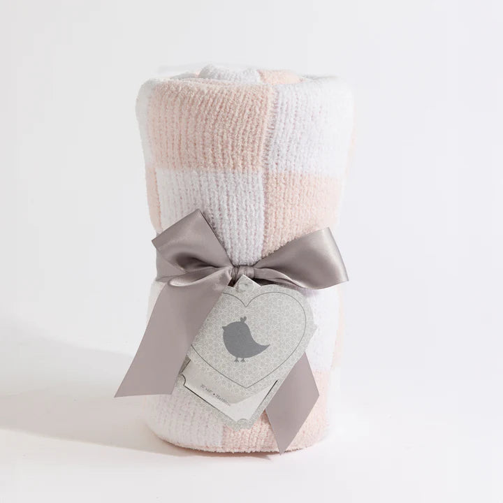 Checkered blanket with a gray bow and heart-shaped tag on a light background