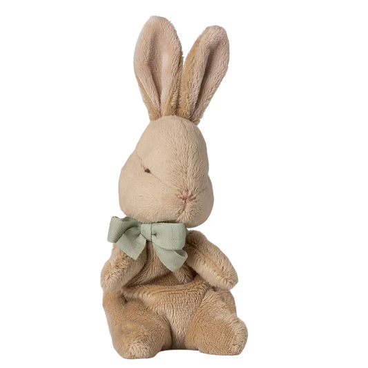 Stuffed bunny toy with a green bow on a white background
