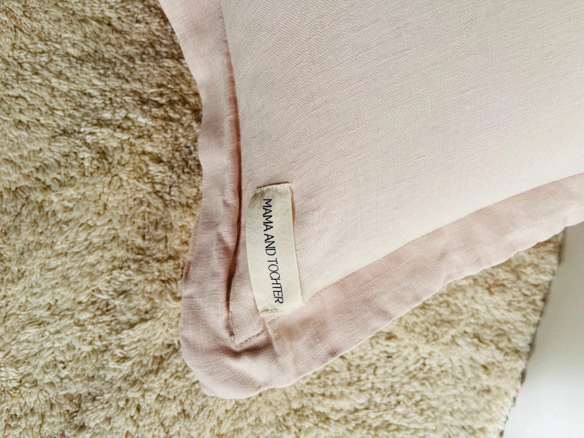 Close-up of a pink fabric with a label on a textured surface