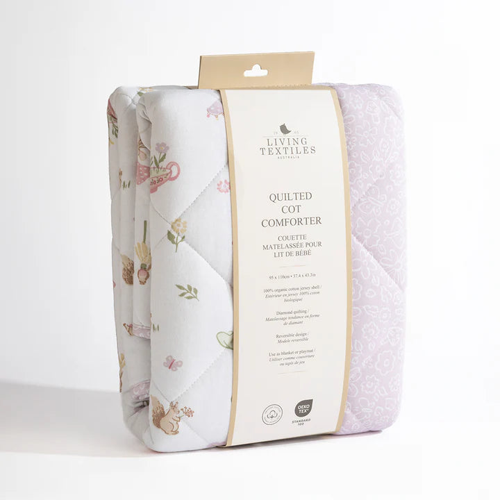 Packaged quilted cot comforter with floral design on a white background