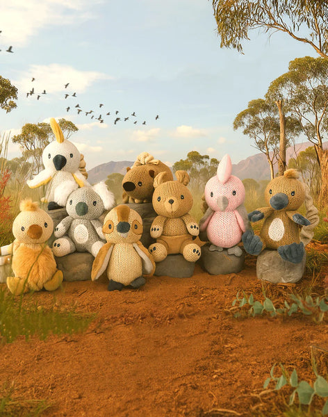 Collection of stuffed animals in a natural setting with trees and birds.