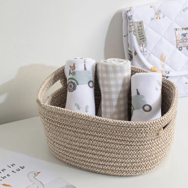 Woven basket with folded baby blankets on a light surface