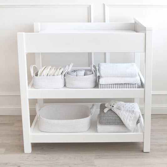 White changing table with baby items in a neutral setting