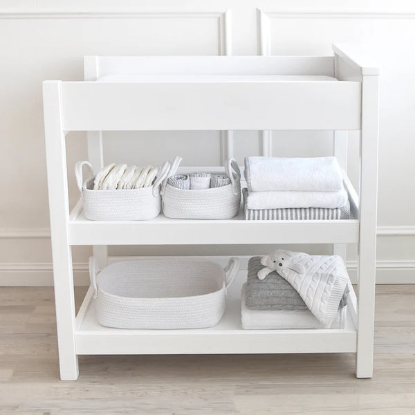 White changing table with baby items in a neutral setting