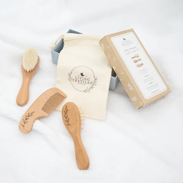 Set of wooden baby brushes and comb with a branded pouch and box on a white background