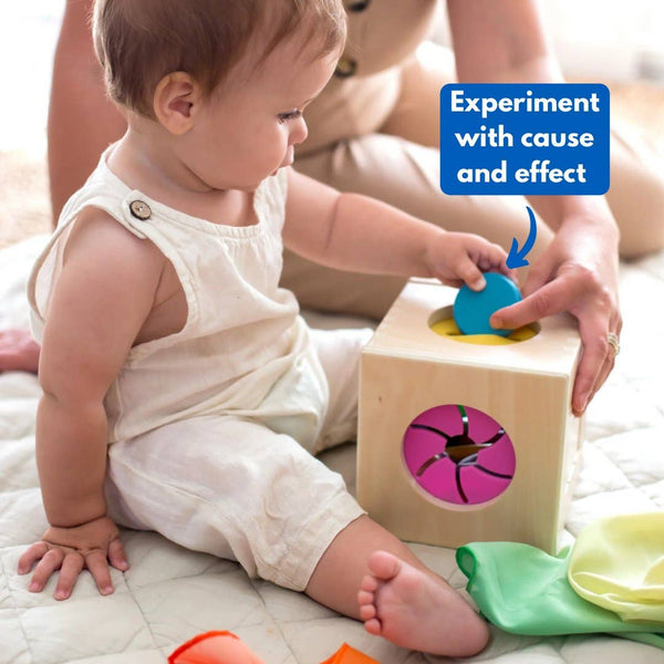 Baby playing with a wooden block toy on a bed
