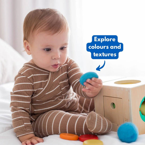 Baby playing with colorful toys on a white surface