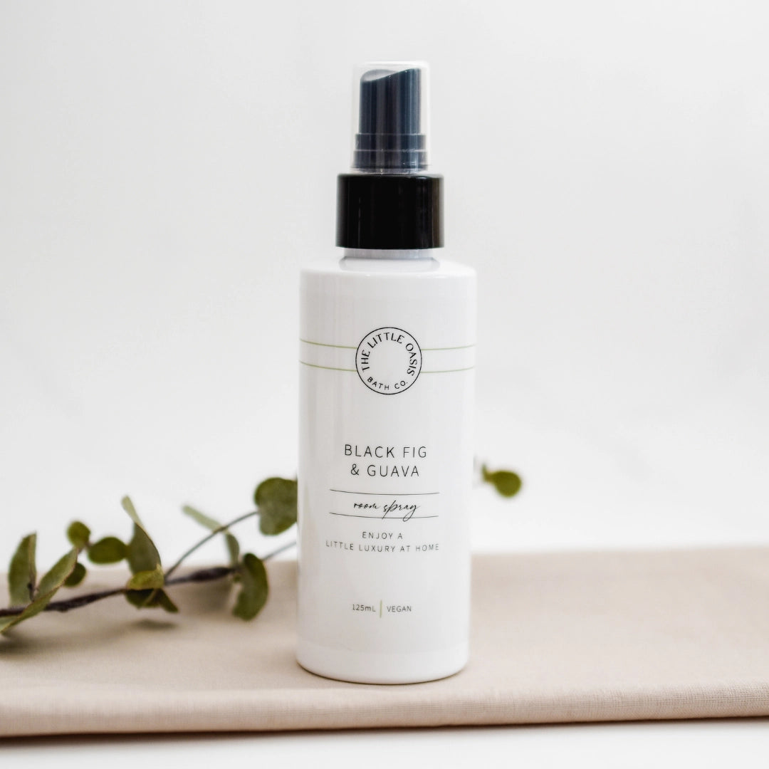 White spray bottle labeled 'Black Fig & Guava' on a light background with green leaves.