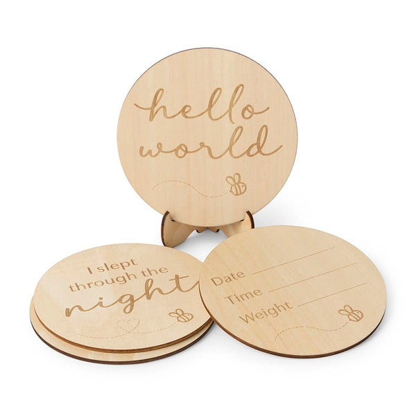Three wooden round placards with engraved text on a white background