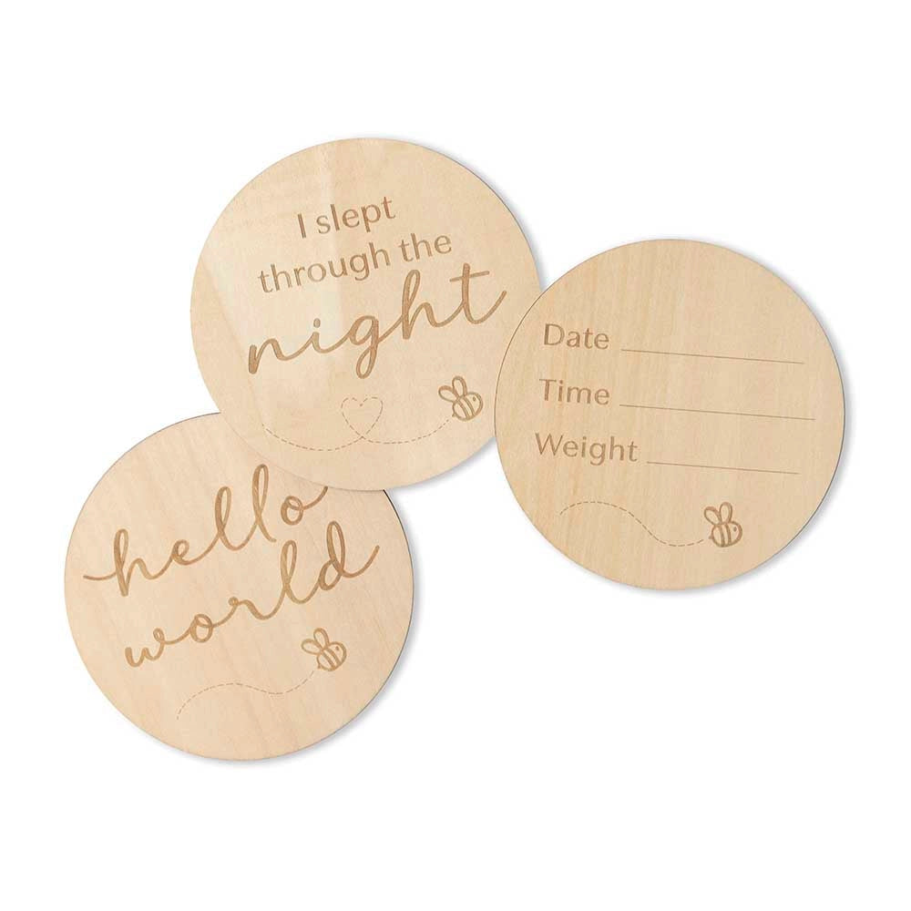Three round wooden cards with engraved text on a white background
