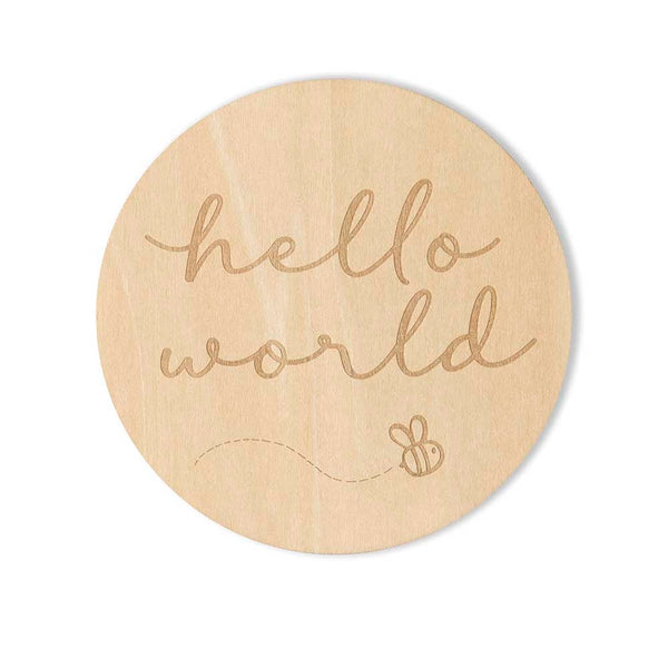 Round wooden disc with 'hello world' and a bee illustration on a white background