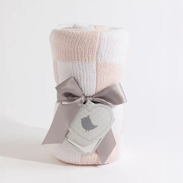 Checkered blanket with a gray bow and heart-shaped tag on a light background