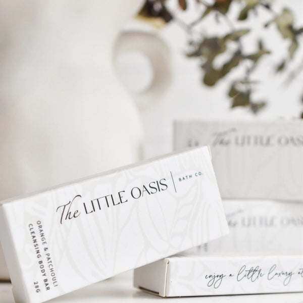 The Little Oasis bath co. packaging on a blurred background