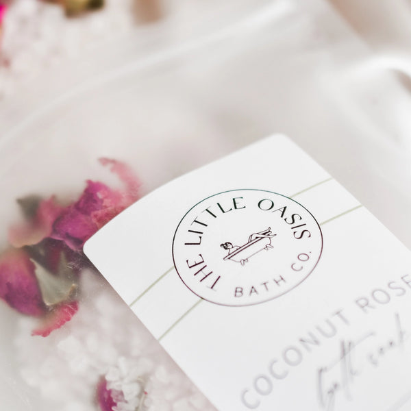 Product packaging with 'The Little Oasis Bath Co.' logo and text on a blurred background.