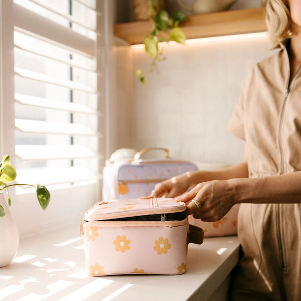 Person interacting with floral-patterned containers on a kitchen counter