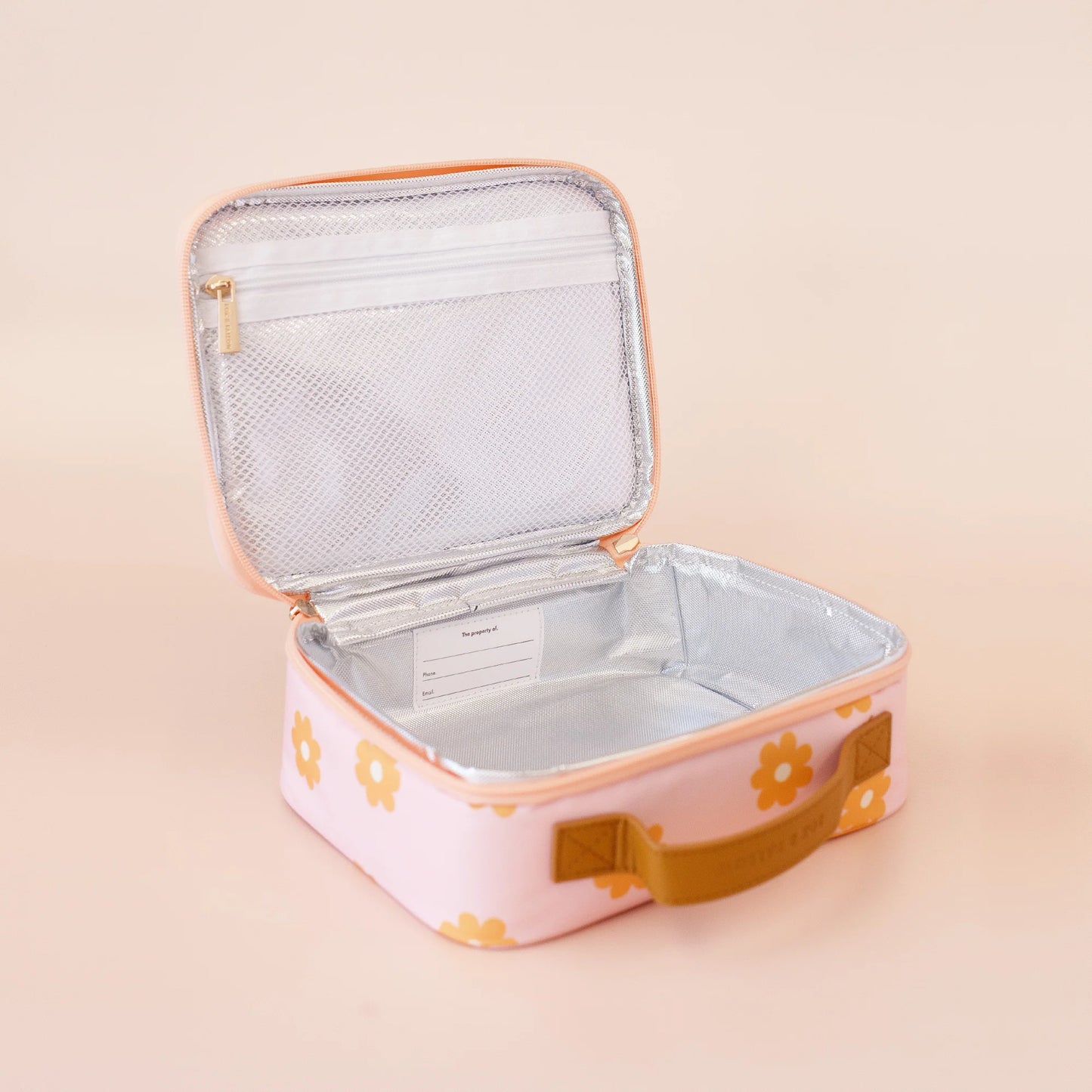 Pink lunch bag with floral design on a beige background