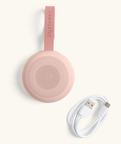 Pink portable speaker with a USB cable on a white background