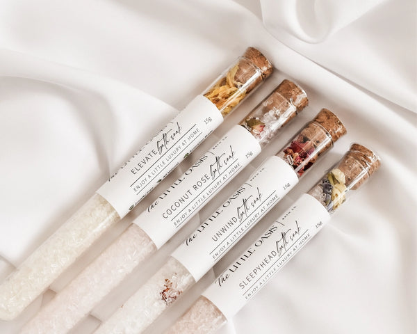 Set of small bottles with labels on a white fabric background