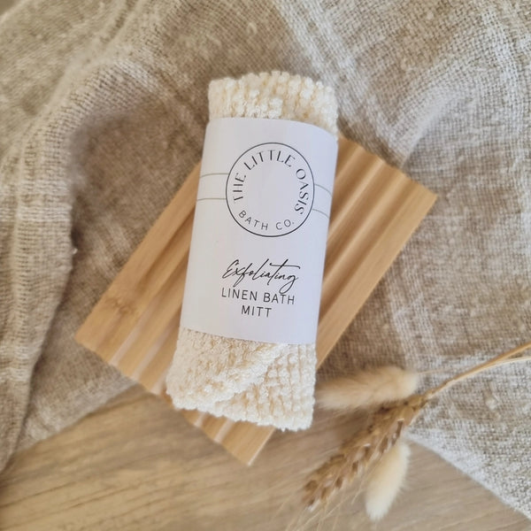 Linen bath mitt with a label on a wooden surface