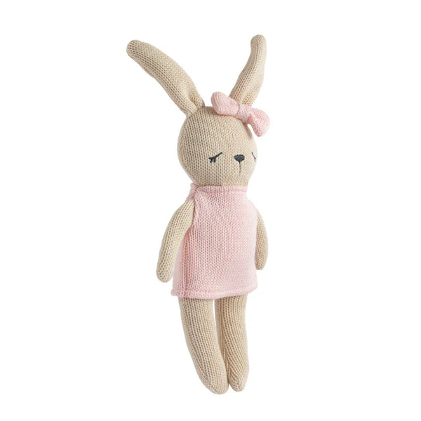 Knitted toy rabbit with a pink dress and bow on a white background