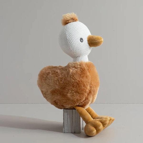 Crocheted duck toy with brown body and white head on a gray background