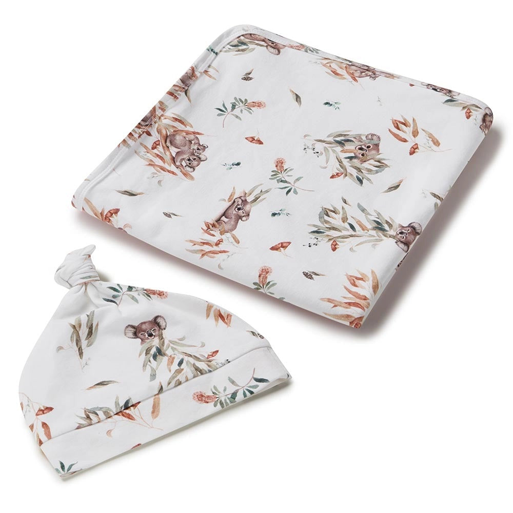 Baby blanket and hat set with koala print on a white background