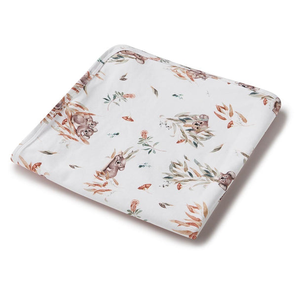Floral patterned fabric with koala designs on a white background