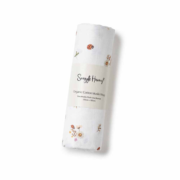 Rolled-up organic cotton muslin wrap with floral patterns on a white background