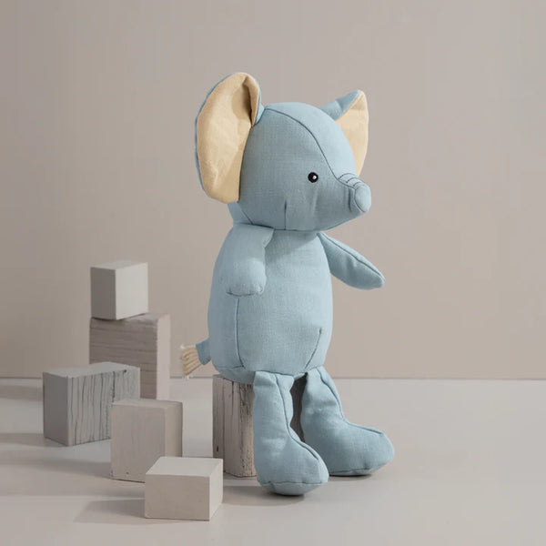 Blue plush elephant toy with wooden blocks on a neutral background