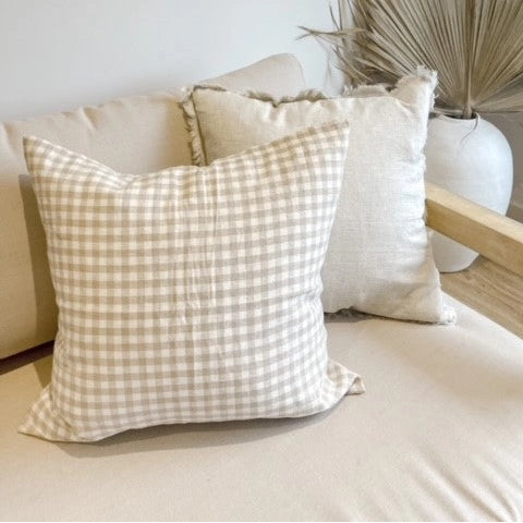 Decorative pillows on a sofa with a neutral background