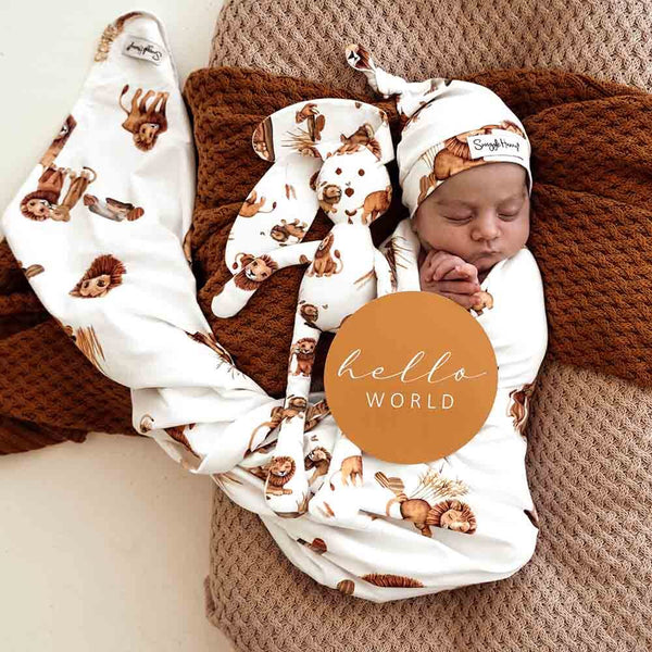 Newborn baby wrapped in a swaddle with animal prints on a brown blanket, featuring 'hello world' text.