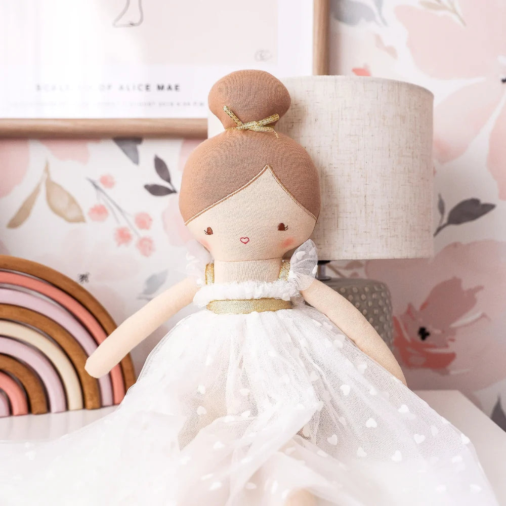 Doll in a white dress with a lamp and decorative elements in the background