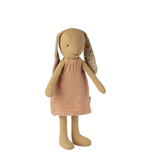 Toy rabbit in a pink dress on a white background