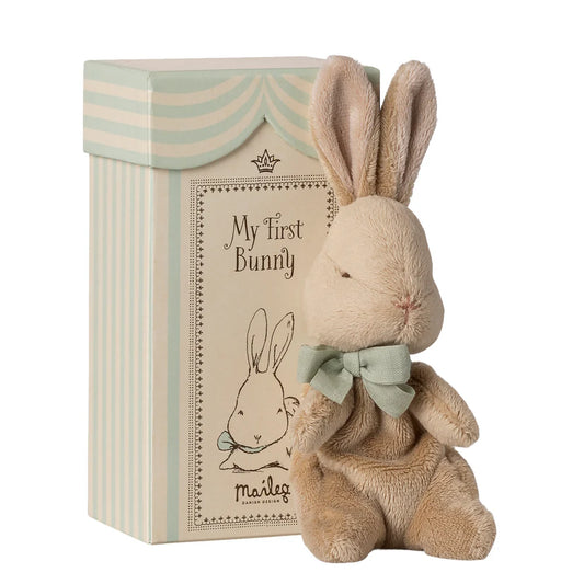 Stuffed bunny toy with a bow tie next to a gift box labeled 'My First Bunny' by Maileg on a white background.