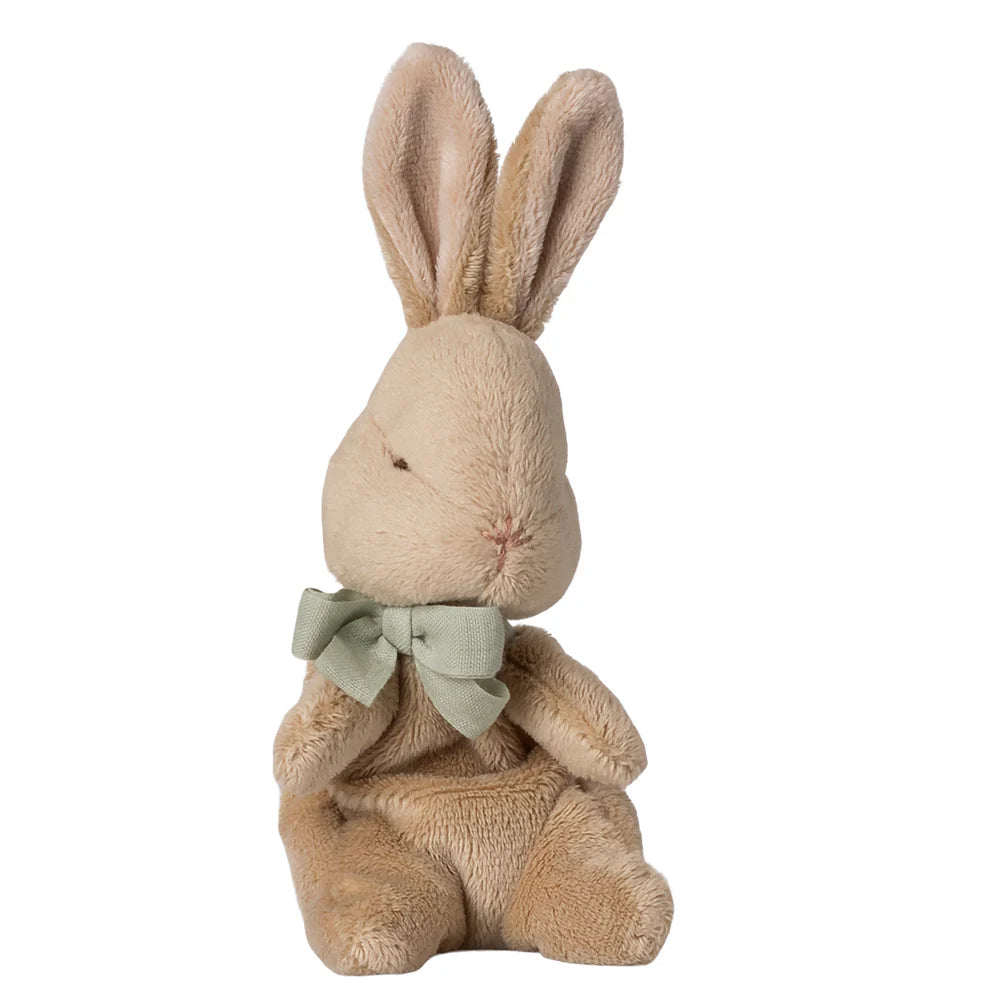 Stuffed bunny toy with a green bow on a white background