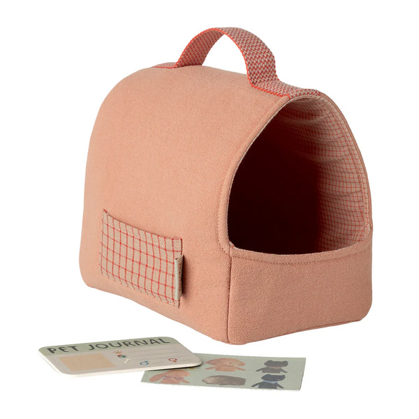 Pink pet carrier with a small window and a handle on a white background