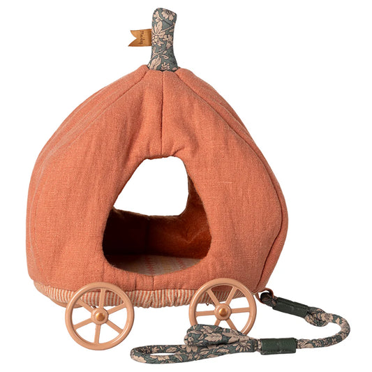 Pumpkin-shaped pet house with wheels and a leash on a white background