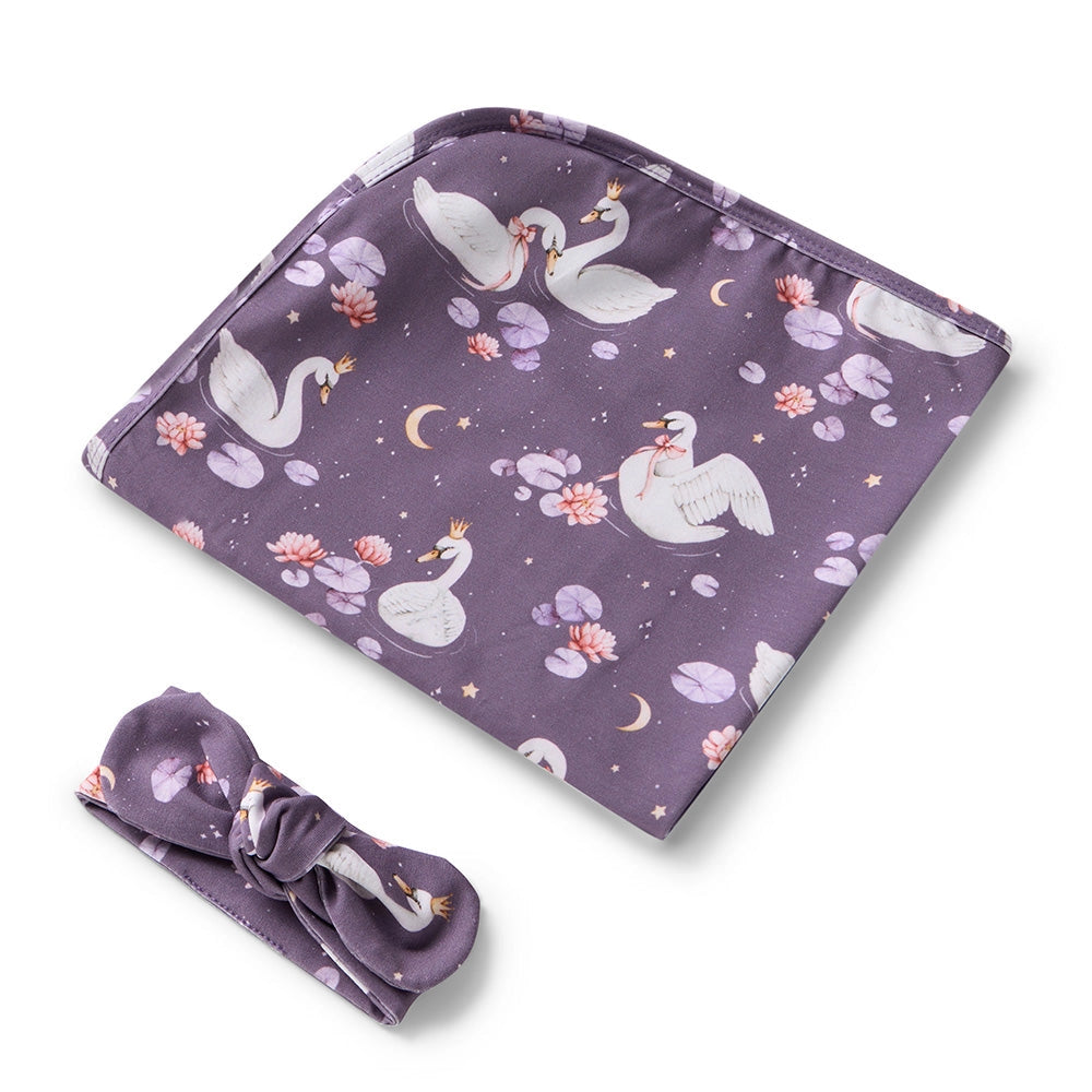 Purple baby blanket with swan design and matching headband on a white background