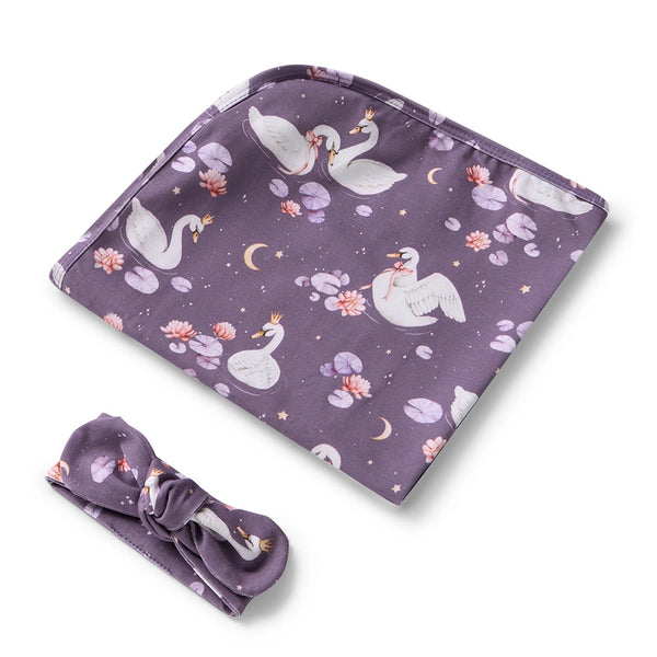 Purple baby blanket with swan design and matching headband on a white background