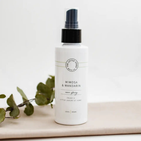 White bottle with black cap labeled 'Mimosa & Mandarin' on a light background