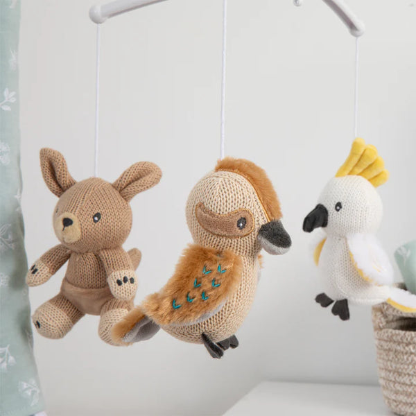 Knitted toys resembling a rabbit, owl, and parrot hanging from a mobile.