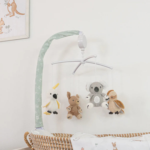 Children's crib mobile with stuffed animals on a white wall