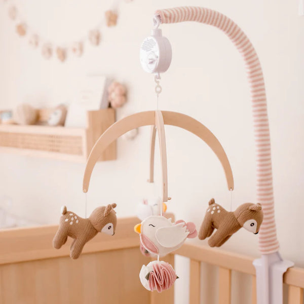 Baby crib mobile with deer and bird designs in a nursery setting