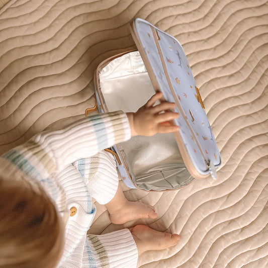 Child playing with a lunch bag on a textured surface