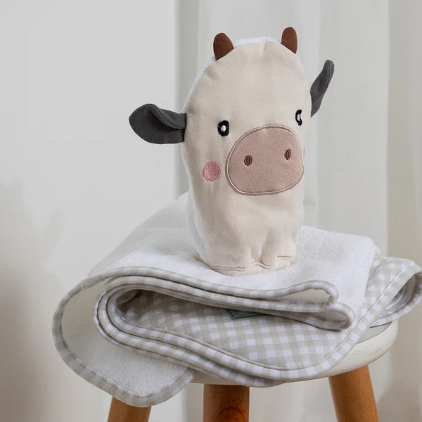 Plush cow toy on a stool with a checkered blanket