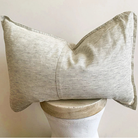 Striped pillow on a stool with a plain background