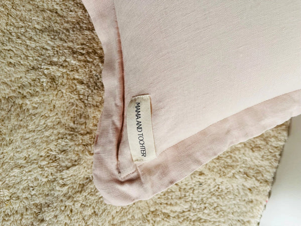 Close-up of a pink fabric with a label on a textured surface