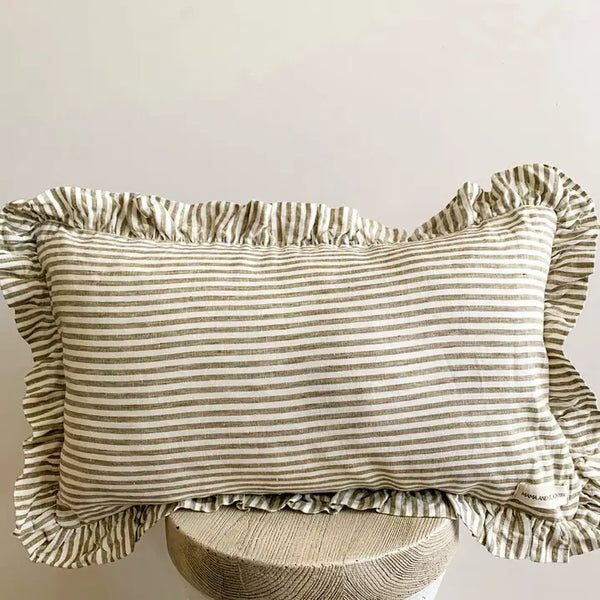 Striped pillow with ruffled edges on a wooden stand against a plain background