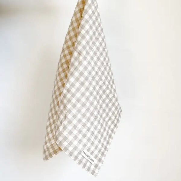 Checkered fabric held by a hand on a white background