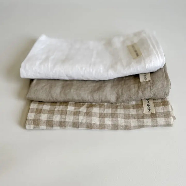 Stack of folded fabric items with tags on a light background
